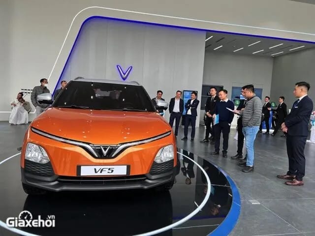Xe điện VinFast VF 5 Plus màu xanh dương đang di chuyển trên đường, biểu tượng cho thành công của một thương hiệu ô tô Việt.