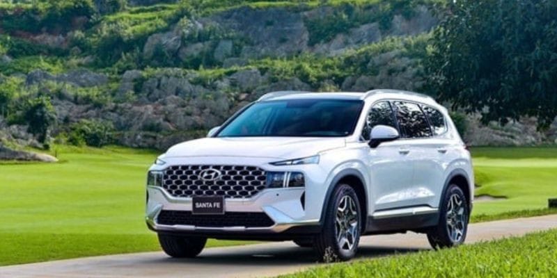 Xe ô tô hạng sang phân khúc E màu đen đỗ trước một tòa nhà hiện đại
