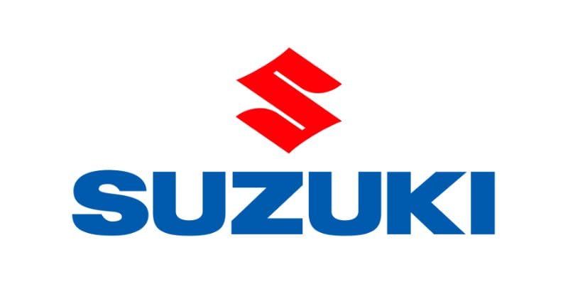 Xe Suzuki Swift màu xanh đỗ trước một tòa nhà
