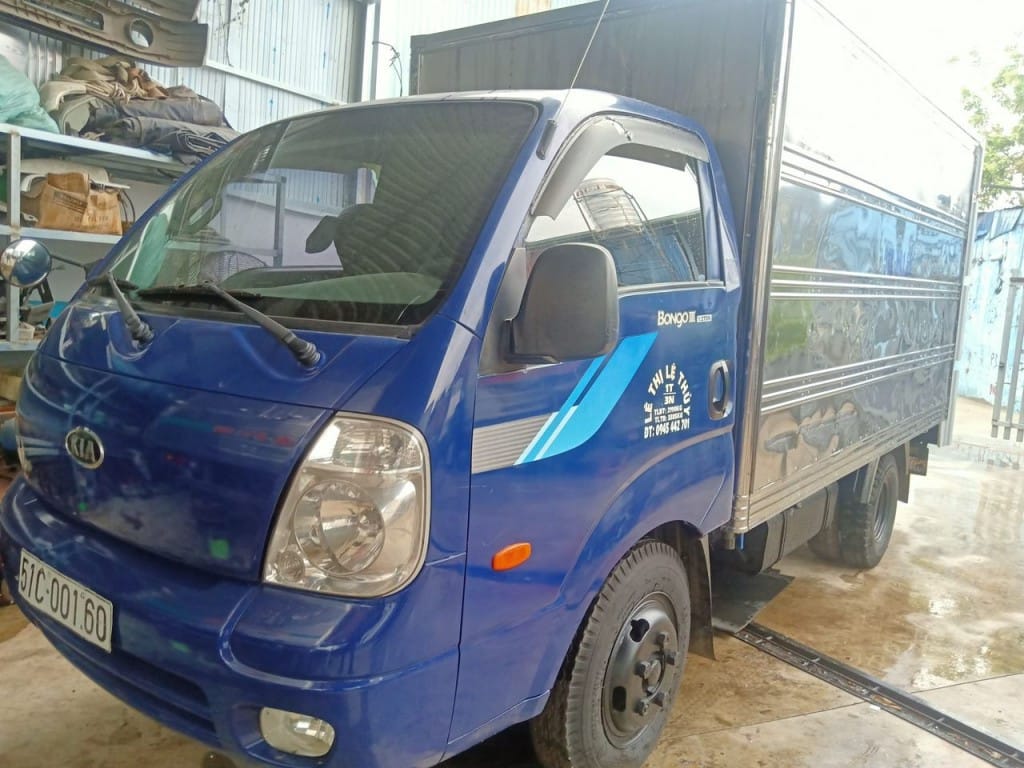 Xe tải 9 tạ cũ Kia Bongo với thùng kín màu trắng đỗ trên vỉa hè
