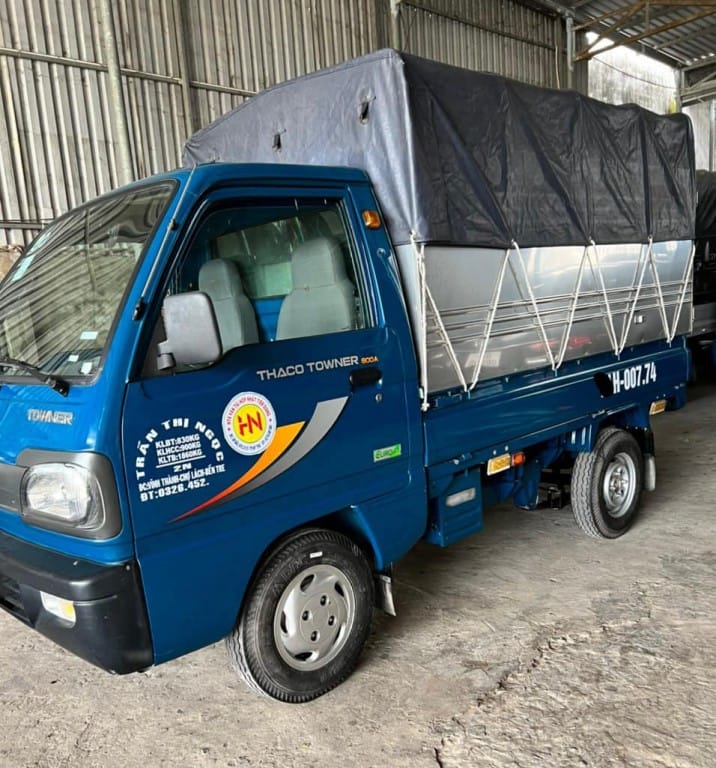 Xe tải 900kg cũ Thaco Towne thùng mui bạt màu xanh đậu trên sân