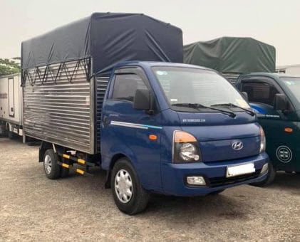 Xe tải Hyundai H100 1 tấn cũ đời 2016 màu xanh với thùng mui bạt, phù hợp nhiều loại hàng hóa.