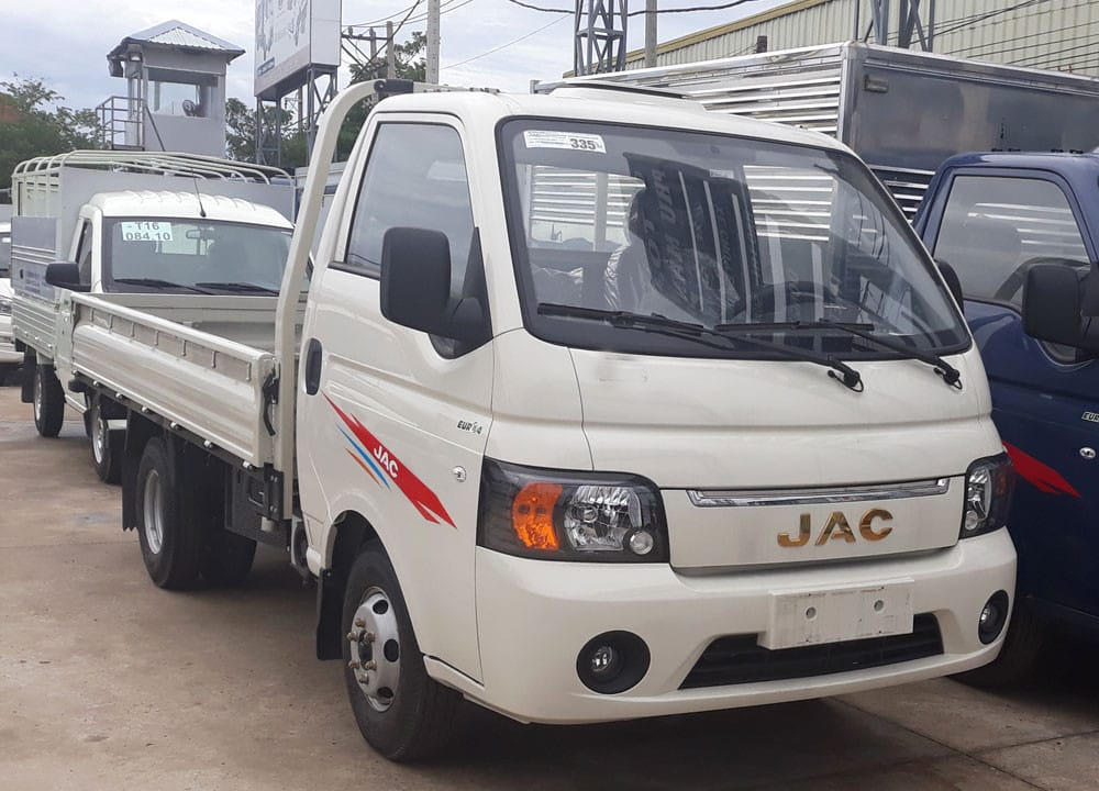Xe tải Jac 1.5 tấn màu trắng đang di chuyển trên đường, thể hiện thiết kế hiện đại