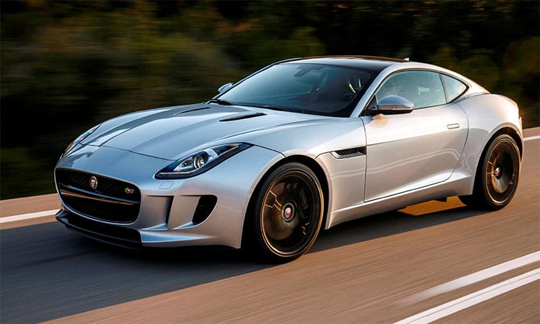 Xe thể thao Jaguar F-TYPE màu vàng rực rỡ đang chạy trên đường, biểu tượng của hiệu suất và thiết kế đẳng cấp của xe Jaguar.
